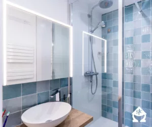 Salle de bain bleue avec une armoire de toilette.